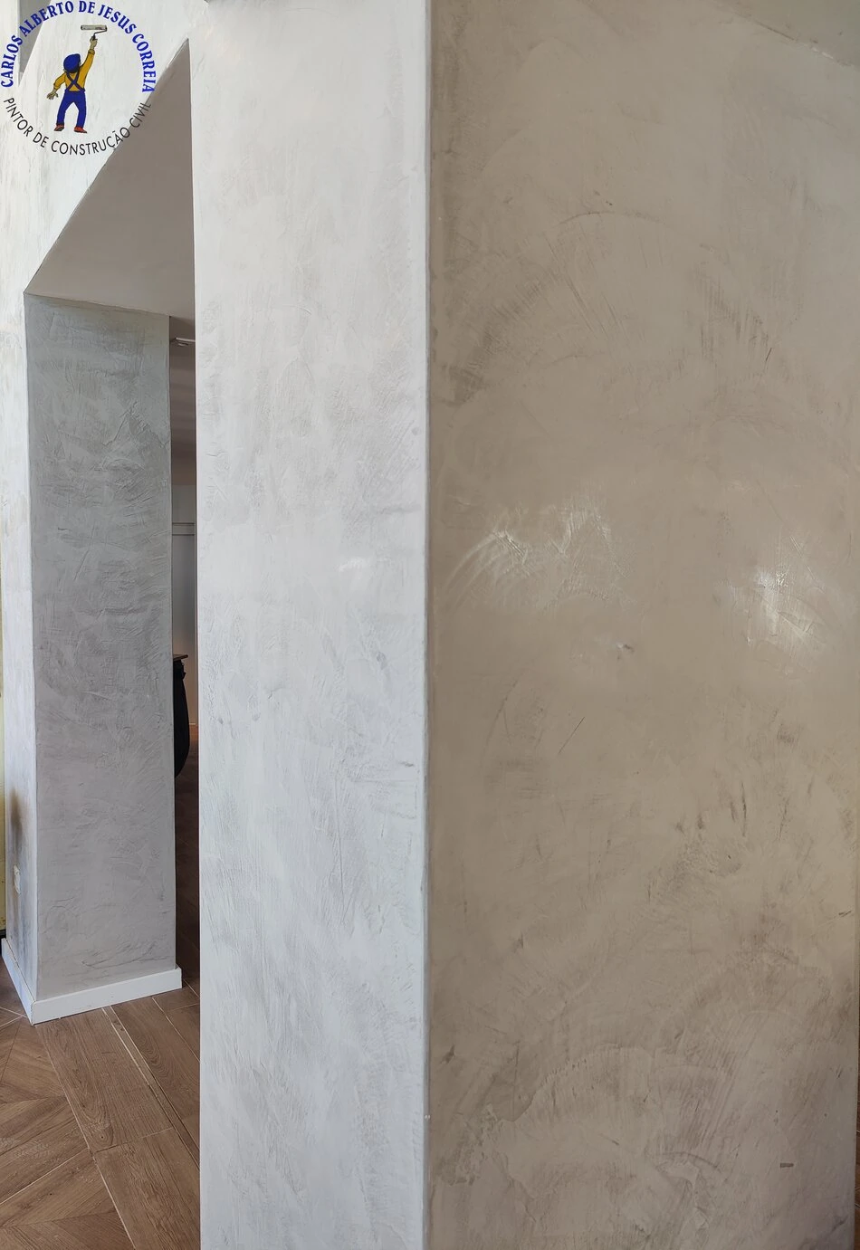 Parede e pilar revestidos com microcimento ou estuque veneziano de cor cinza claro. Trabalho de pintura e decoração de interiores.